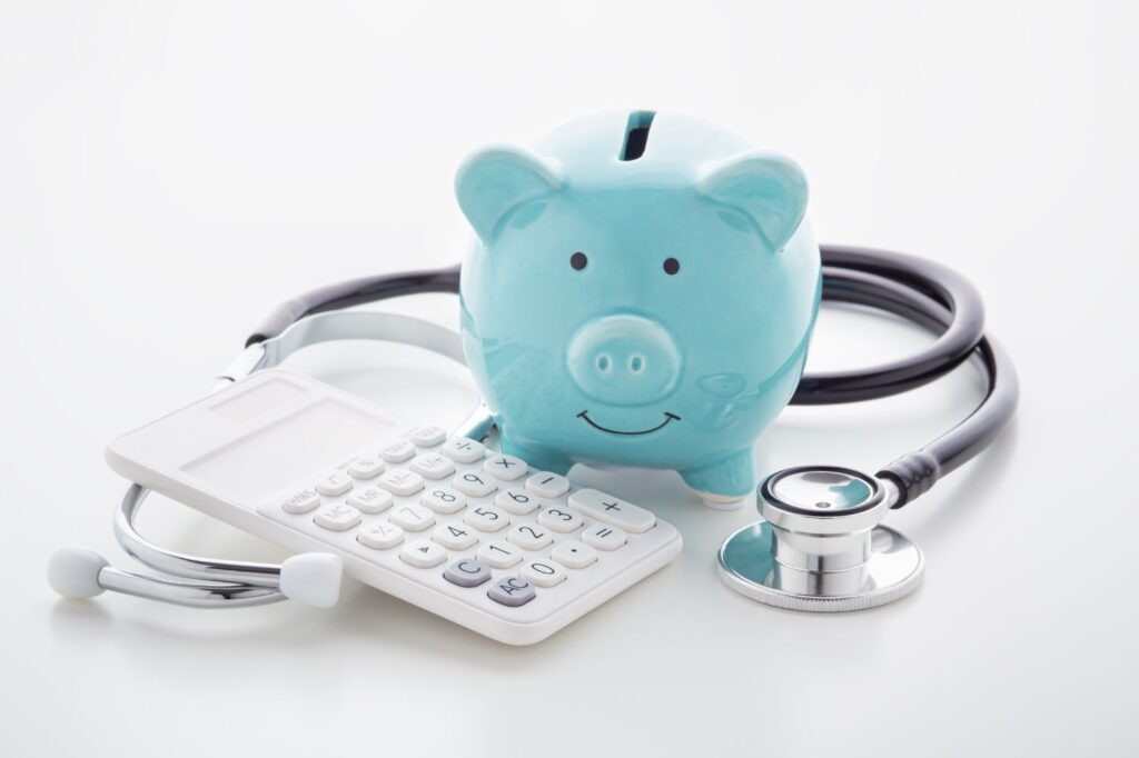 Smiling blue piggy bank with a calculator and stethoscope.