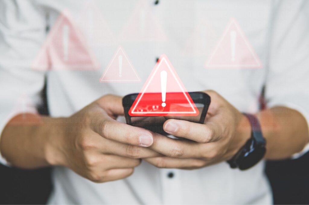 Man checking his phone with red warning notifications.