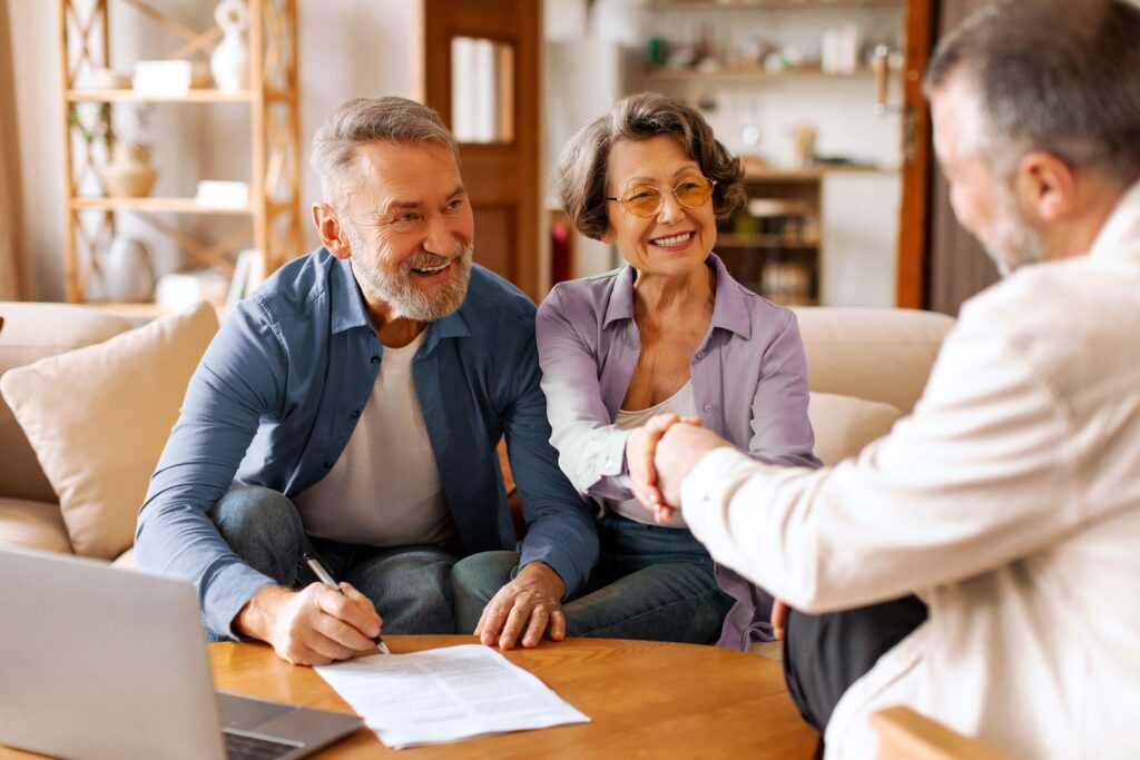 Happy mature couple sitting with advisor.
