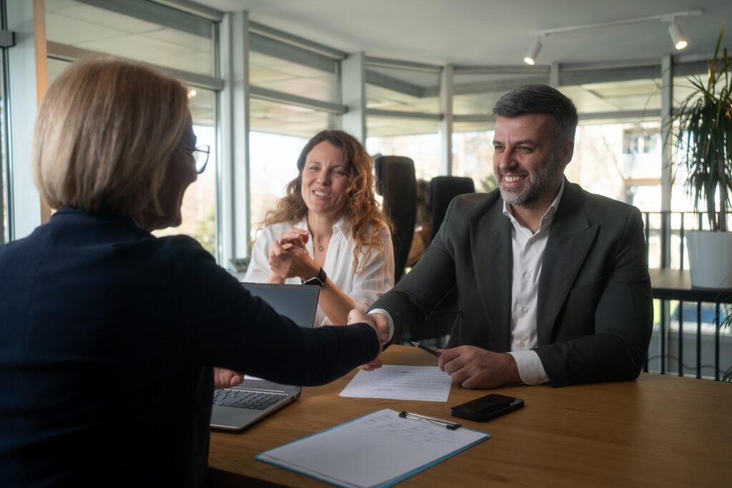 Mature man and woman doing business with another woman.