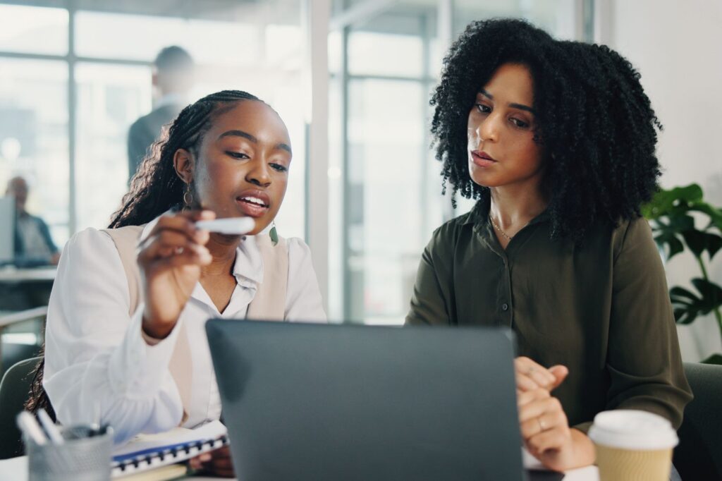 Two women looking over a tablet together.