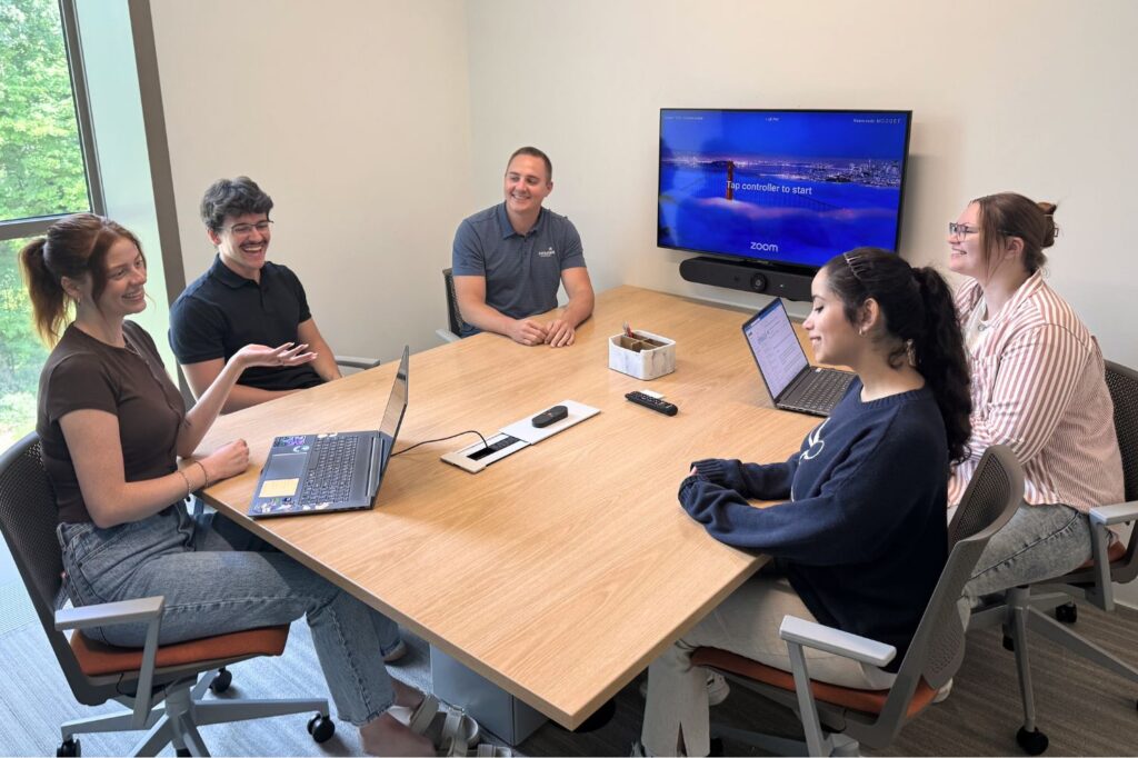 Group of Consumers team members sitting in a conference room doing an ice breaker.
