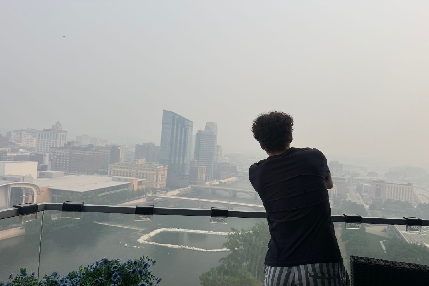 Person looking out over Grand Rapids covered in wildfire smoke.