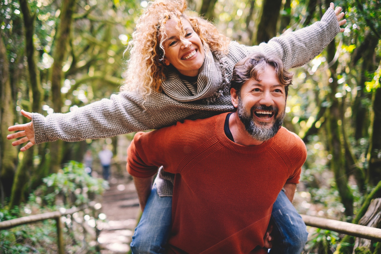 Happy adult couple having fun in the woods.