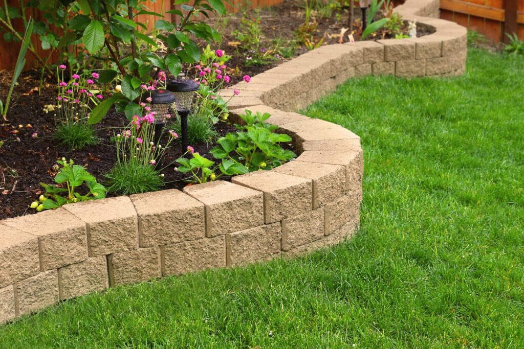 Stone wall with grass landscaping in a garden.