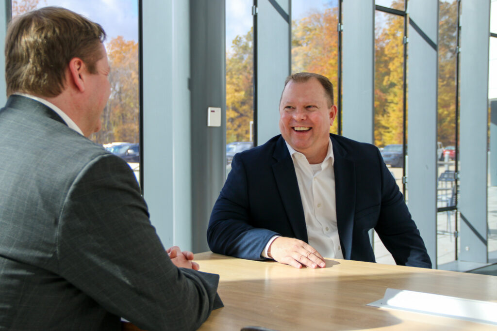 Commercial Loan Officer Ed Case smiling while sitting with another person.