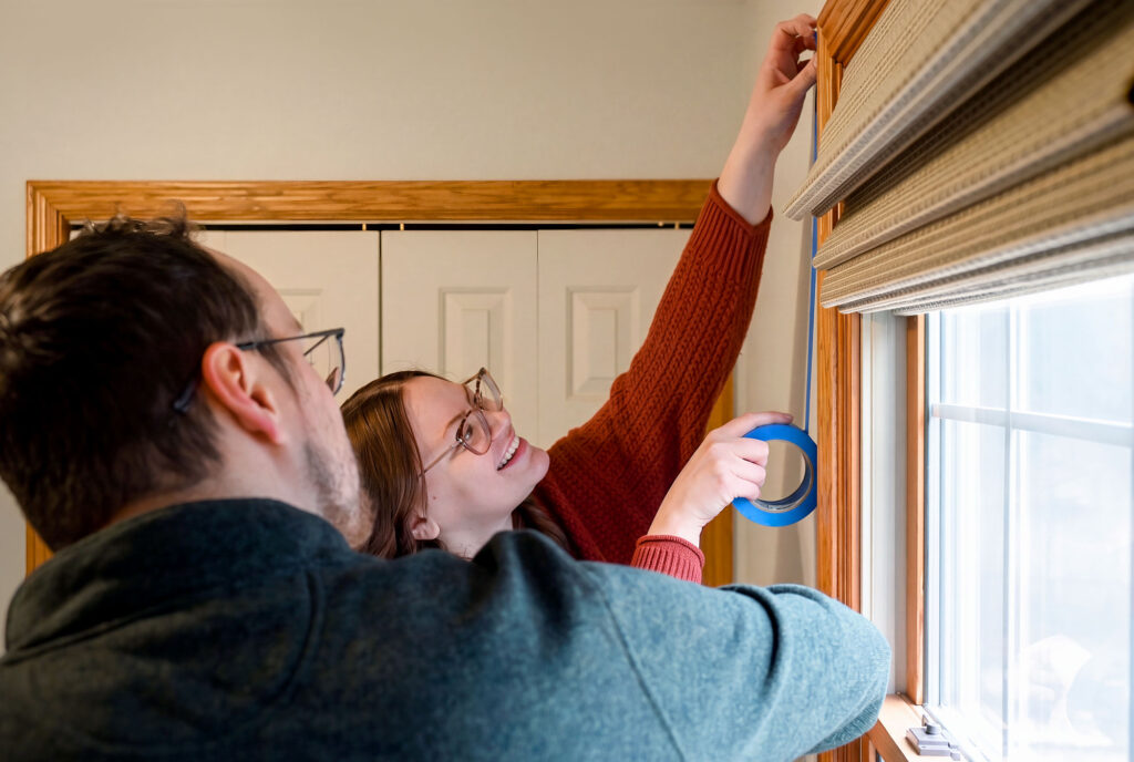 Homeowners smiling while holding a measuring tape.