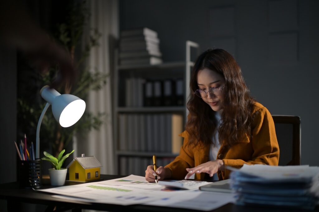 Young businesswoman sitting at a desk and looking over paperwork.